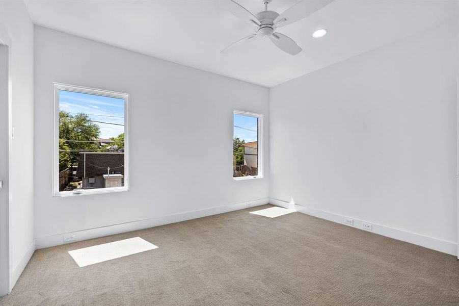 Carpeted spare room featuring ceiling fan