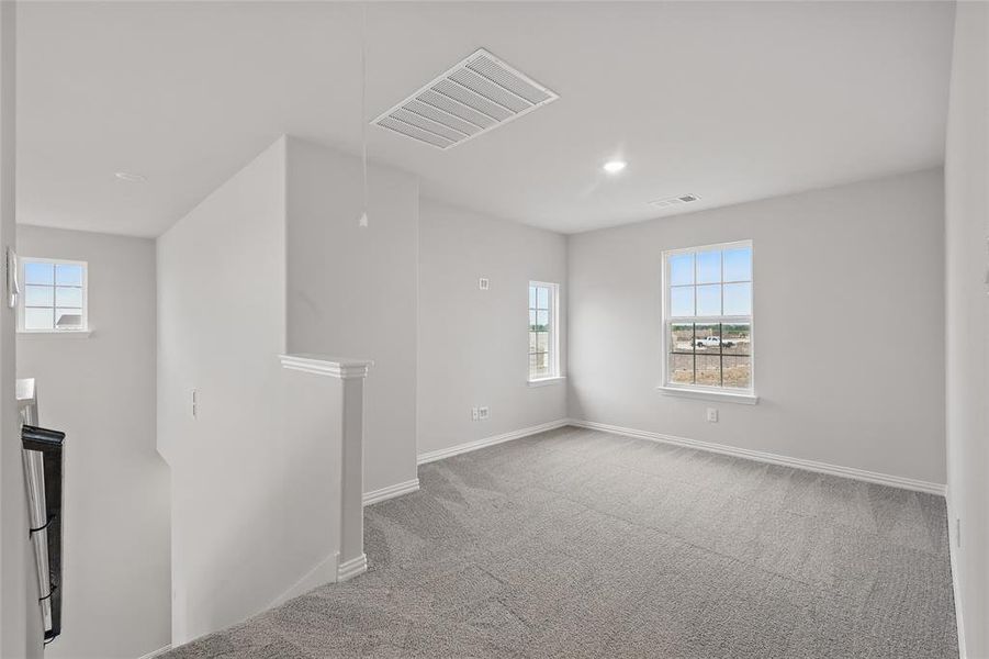 Carpeted spare room with plenty of natural light and recessed lighting