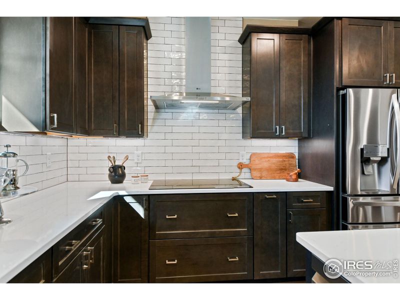 The spice rack next to the induction cooktop is just one of many thoughtful design features that makes this kitchen as functional as it is stylish.