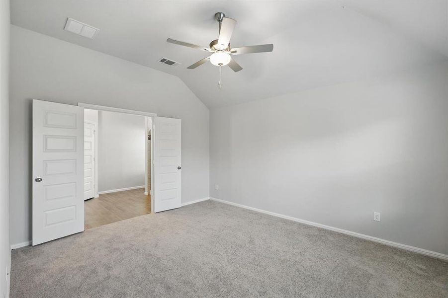Unfurnished bedroom with lofted ceiling, carpet floors, and ceiling fan Unfurnished bedroom with lofted ceiling, carpet floors, and ceiling fan