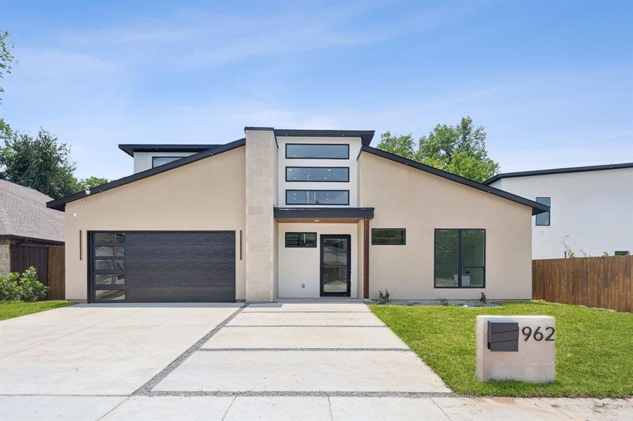 Contemporary house featuring a front yard and a garage