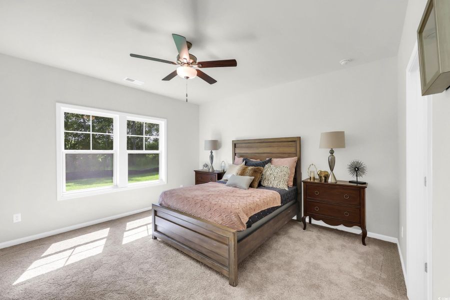 Bedroom with light colored carpet and ceiling fan