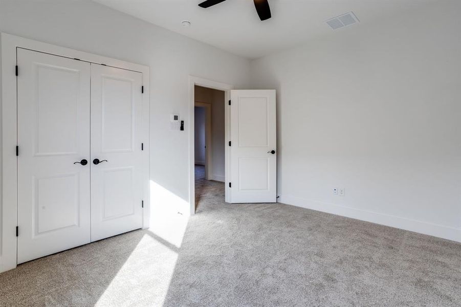 Unfurnished bedroom with light carpet, a closet, and ceiling fan