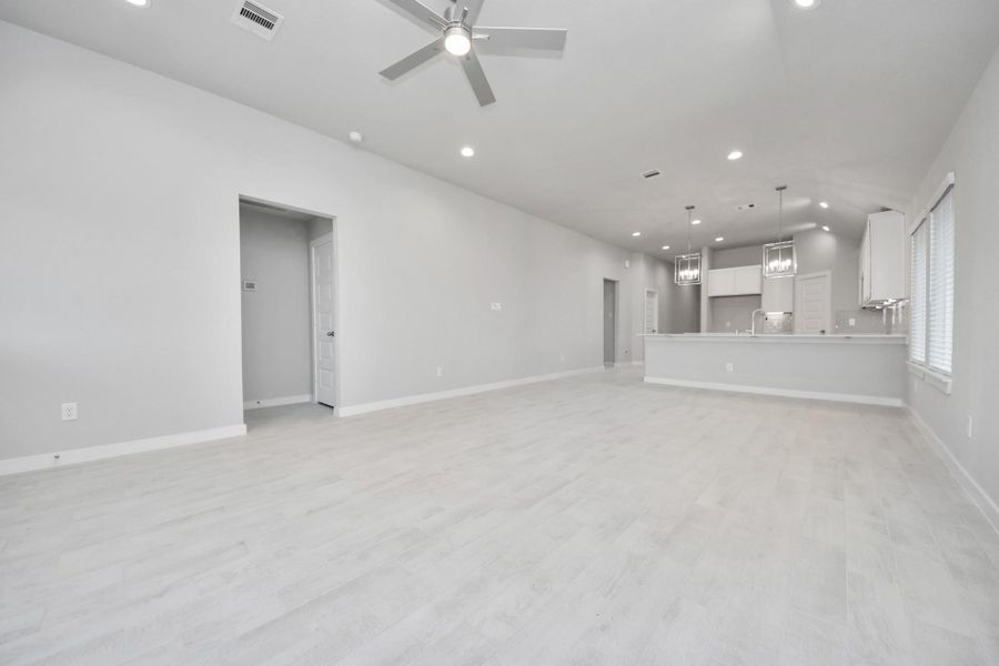 Relax and unwind in this inviting family room, illuminated by abundant natural light streaming in through tall windows, complemented by high ceilings and stunning flooring. Stay comfortable year-round with the gentle breeze from the ceiling fan, creating the perfect atmosphere for family gatherings. Sample photo of completed home with similar floor plan. Actual colors and selections may vary.