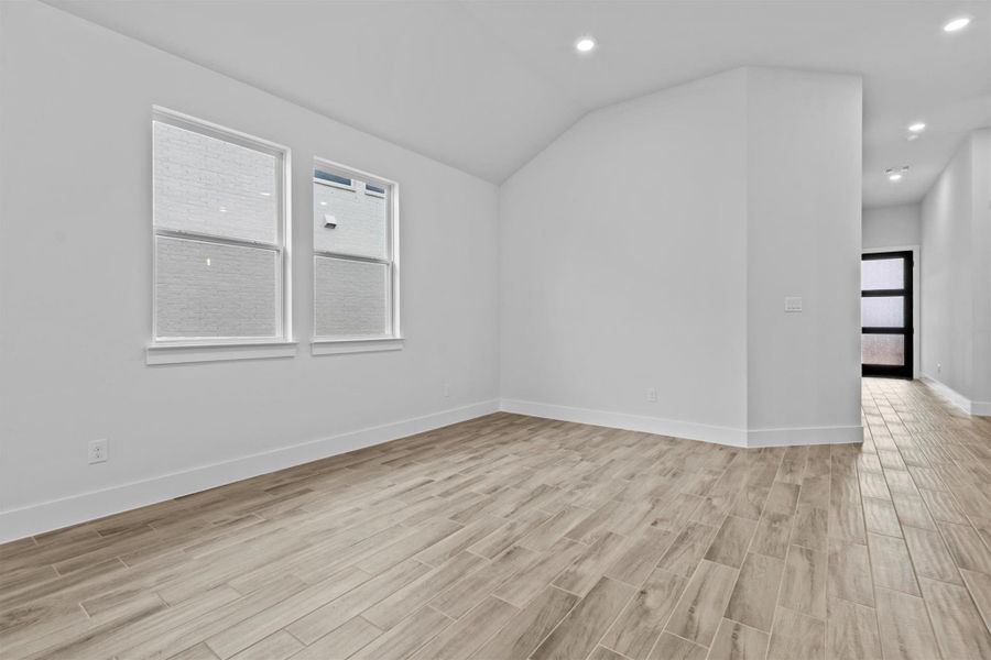 Empty room featuring vaulted ceiling