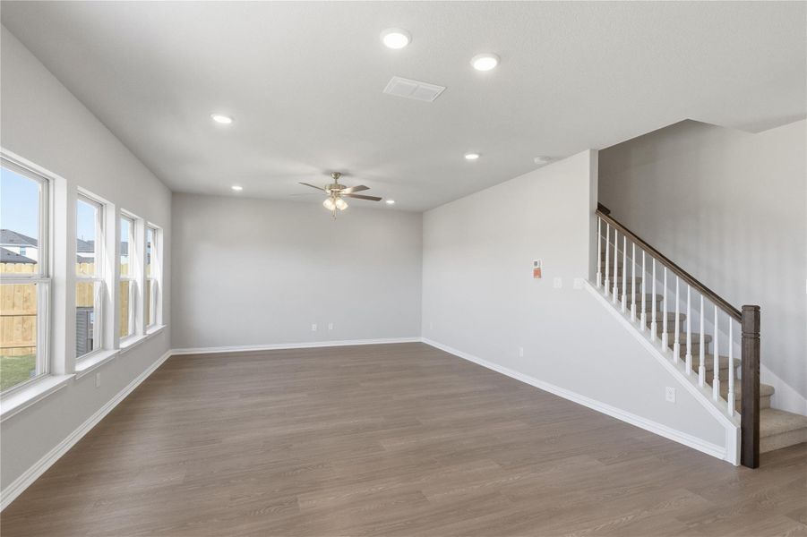 Unfurnished living room featuring recessed lighting, wood finished floors, stairway, and a ceiling fan