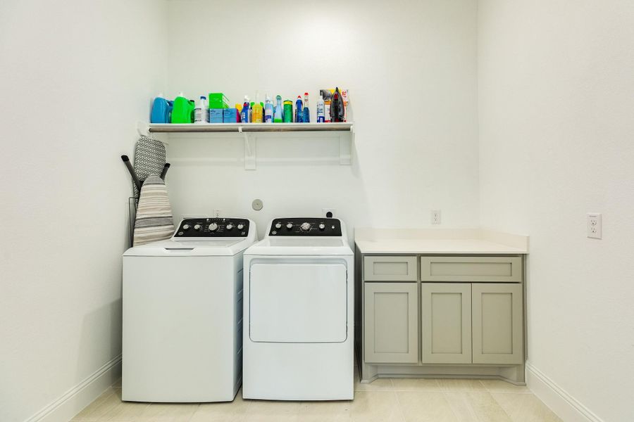 This laundry room is exceptionally spacious and features a convenient folding table with built-in storage. Additionally, it includes an under-stair closet that provides excellent extra storage space or the potential to be utilized as a mudroom.
