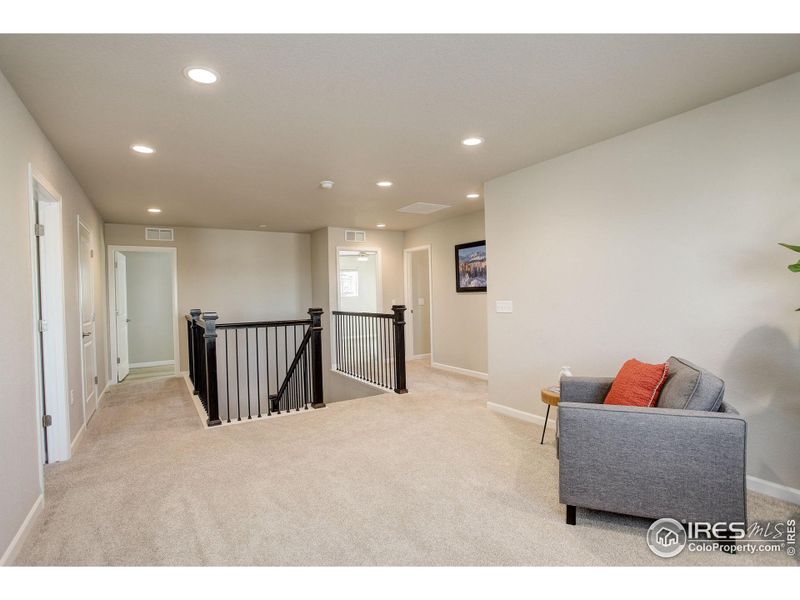 Large upstairs loft greets you at the top of the stairs. You will find upgraded stair railings in the home!