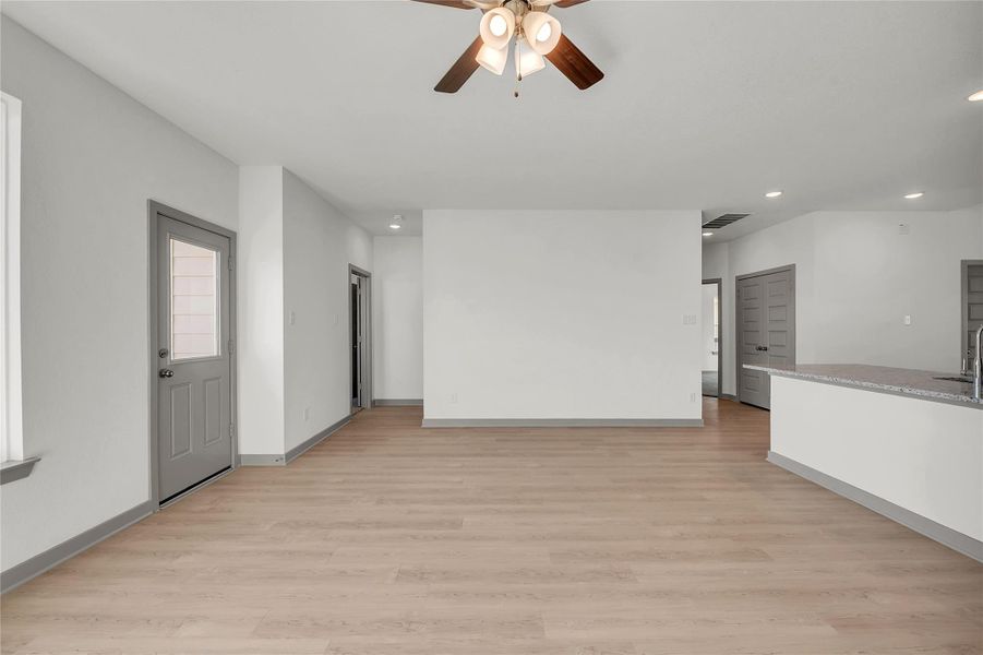 Unfurnished living room featuring light wood-type flooring, a ceiling fan, and recessed lighting