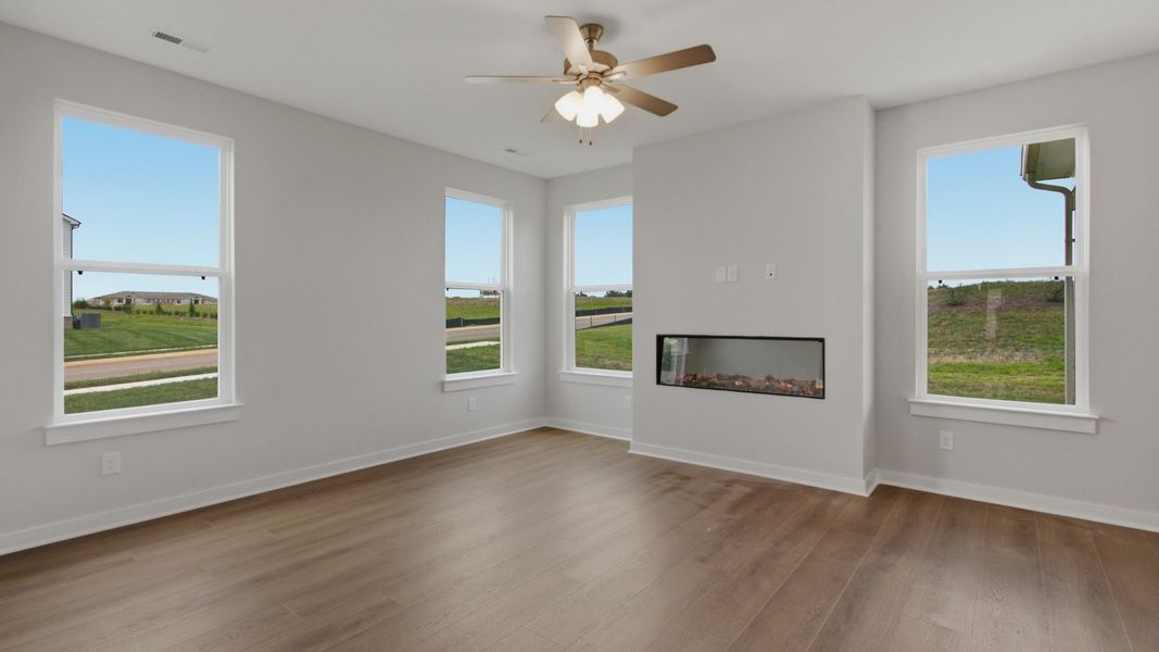 Spacious living area with ceiling fan and fireplace Spacious living area with ceiling fan and fireplace
