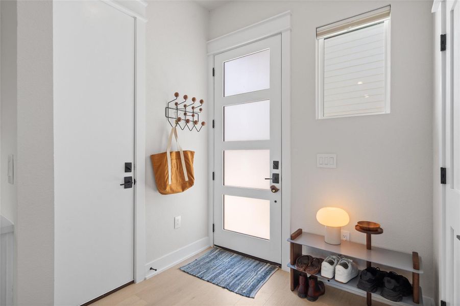 A well-lit entry with sleek modern design and warm wood flooring welcomes all who enter. A well-lit entry with sleek modern design and warm wood flooring welcomes all who enter.