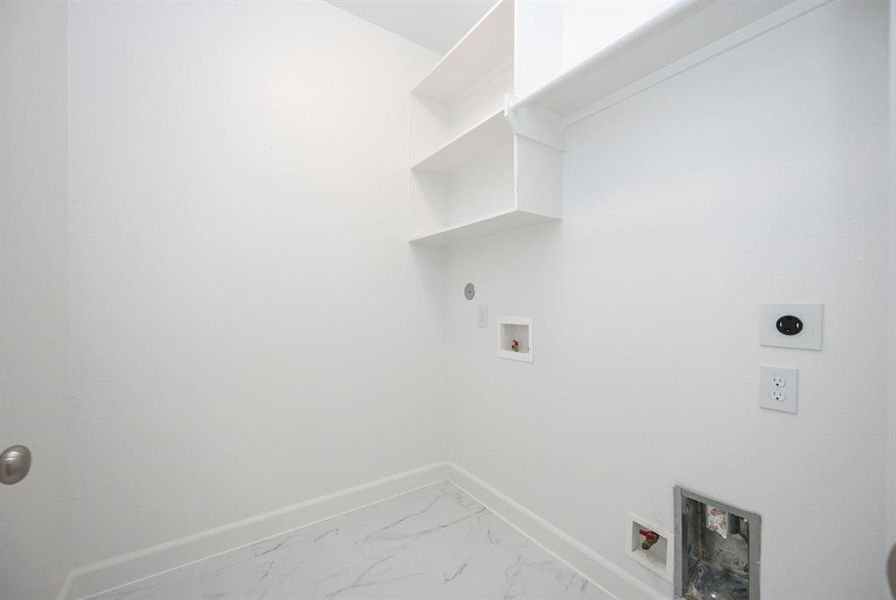 Imagine the convenience of this full-sized laundry room with space for a side-by-side washer and dryer, plus built-in shelves and hanging space.