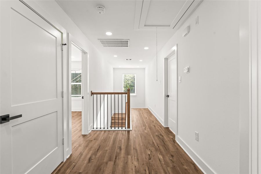 Thoughtful zoning. The upper level separates the bedrooms seamlessly with a clean, bright corridor anchored by beautiful iron spindle details.