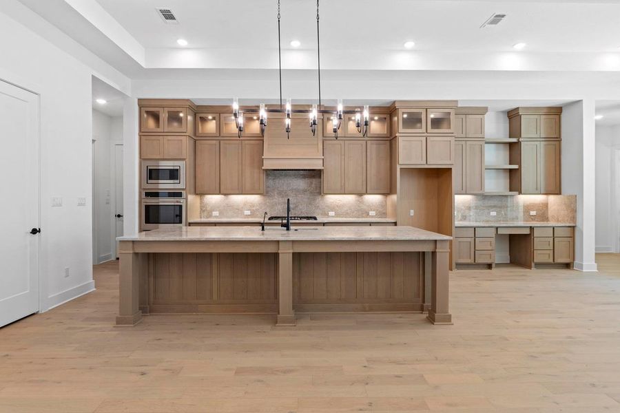 Kitchen with tasteful backsplash, glass insert cabinets, light wood-style floors, and recessed lighting Kitchen with tasteful backsplash, glass insert cabinets, light wood-style floors, and recessed lighting