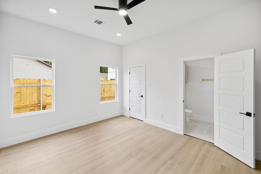 Unfurnished bedroom featuring light wood-type flooring, connected bathroom, recessed lighting, and a ceiling fan