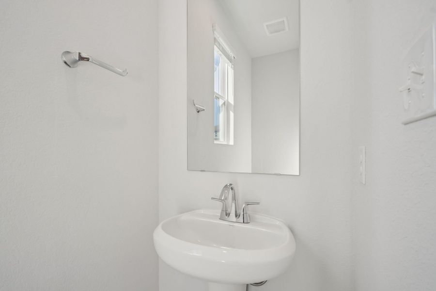 A bathroom with a mirror and sink.