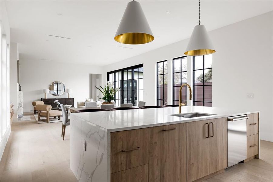 Kitchen with modern cabinets, a kitchen island with sink, pendant lighting, and a sink