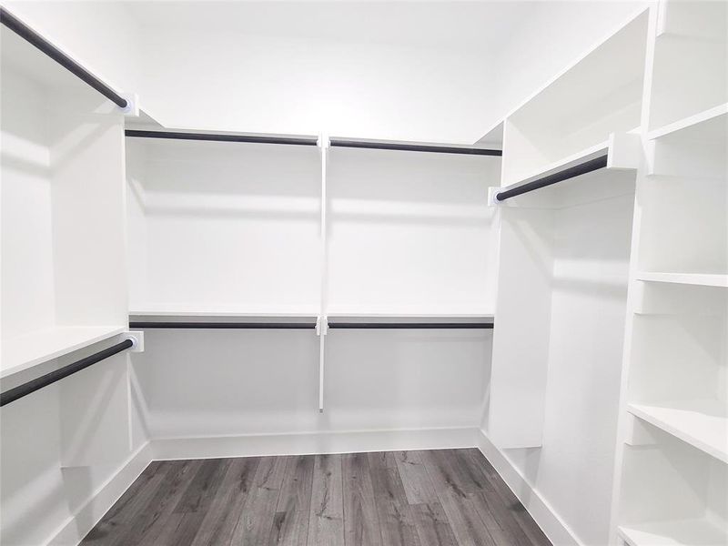 Spacious closet with dark wood-type flooring Spacious closet with dark wood-type flooring