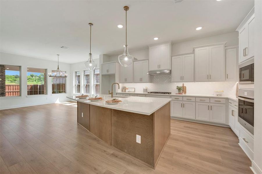 Open-concept living space featuring wood-finish flooring Open-concept living space featuring wood-finish flooring