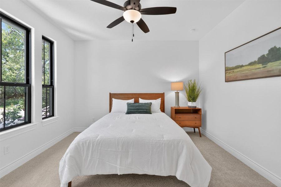 Relax in this tranquil bedroom, featuring a warm wooden headboard and a practical ceiling fan for comfort. Relax in this tranquil bedroom, featuring a warm wooden headboard and a practical ceiling fan for comfort.