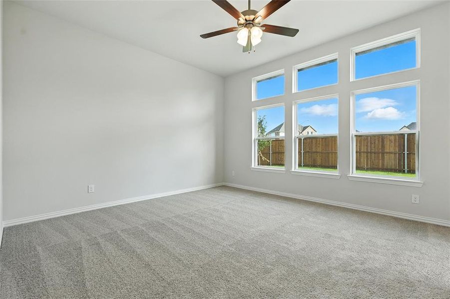Carpeted spare room with baseboards and a ceiling fan