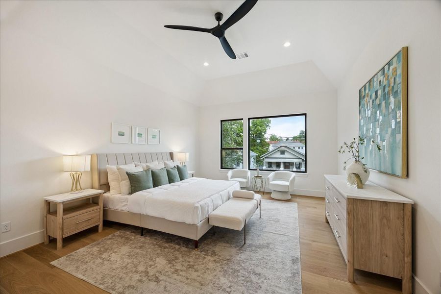Primary suite – features a raised ceiling, ceiling fan, and wood flooring. Primary suite – features a raised ceiling, ceiling fan, and wood flooring.