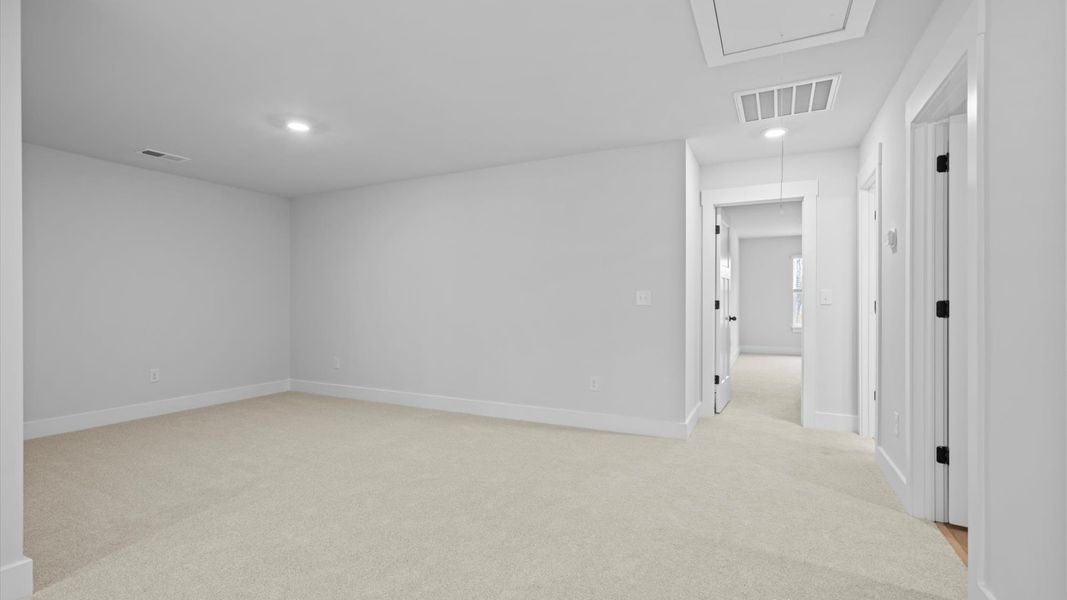 Vibrant carpeted loft offering flexibility as a study nook, game room, or second family space