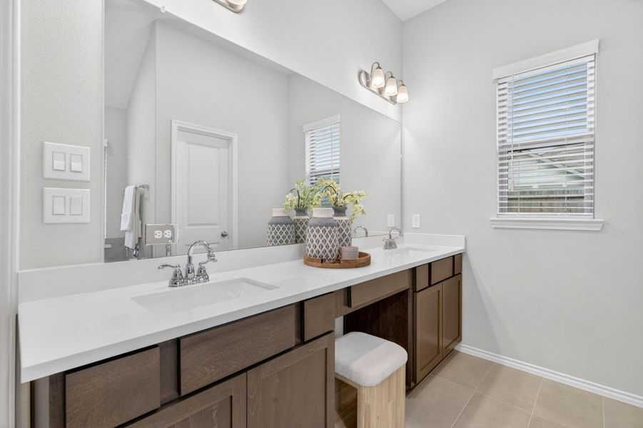This modern bathroom features a spacious double vanity with sleek white countertops and dark wood cabinets. The large mirror enhances the space, complemented by elegant lighting fixtures. A small window provides natural light, and the overall design is clean and inviting. This modern bathroom features a spacious double vanity with sleek white countertops and dark wood cabinets. The large mirror enhances the space, complemented by elegant lighting fixtures. A small window provides natural light, and the overall design is clean and inviting.