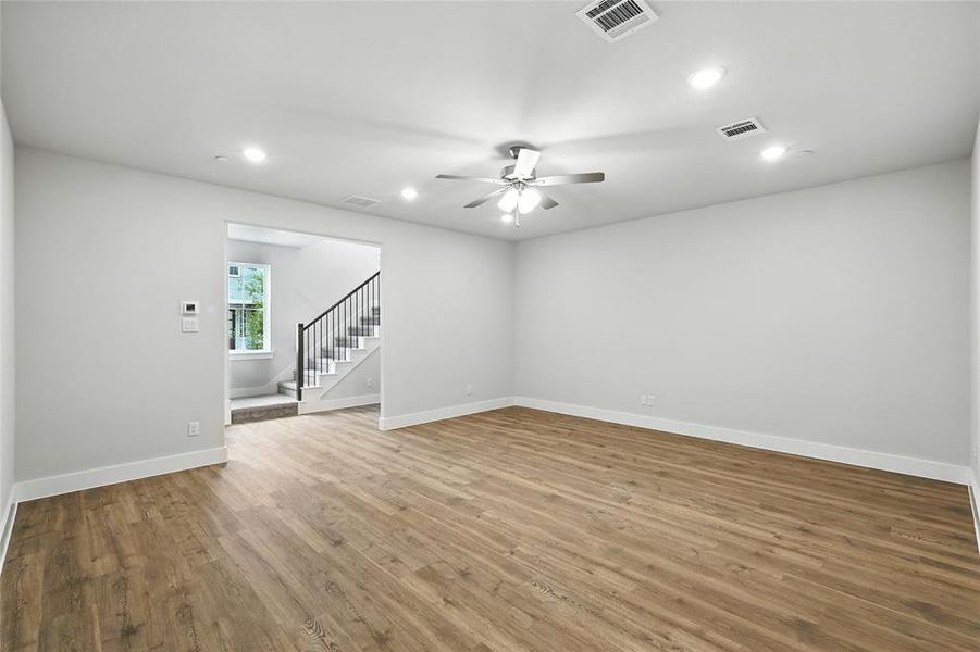 Spare room featuring recessed lighting, light wood finished floors, stairs, and a ceiling fan