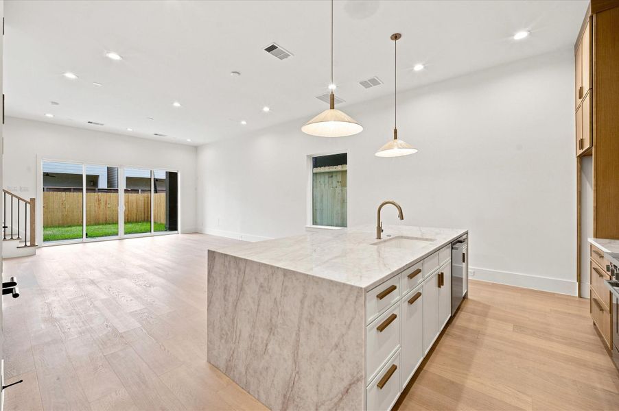 The quartz waterfall island anchors the chef's kitchen, which opens seamlessly to the living and dining areas for effortless everyday living and entertaining.