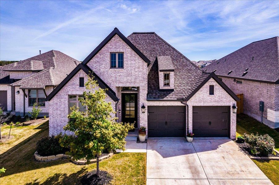 View of front facade featuring brick siding, concrete driveway, and a garage