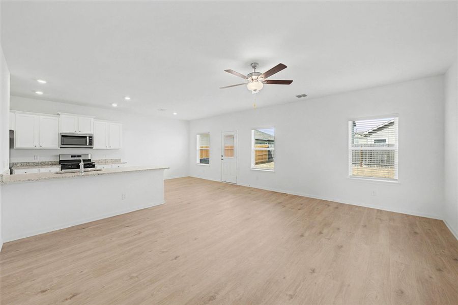 An open-concept living space integrates a well-appointed kitchen with light wood flooring and abundant natural light. An open-concept living space integrates a well-appointed kitchen with light wood flooring and abundant natural light.