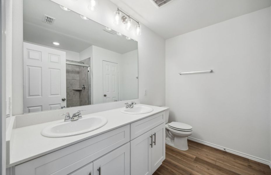 Elegant owner's suite with dual vanity *real home pictured