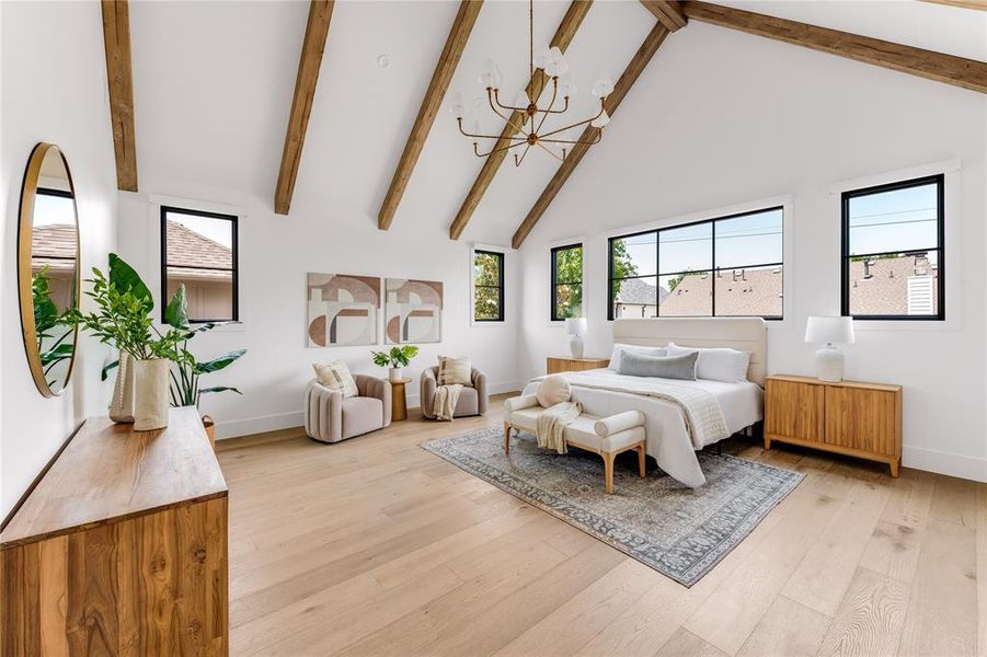 Bedroom featuring light hardwood / wood-style floors, beam ceiling, an inviting chandelier, and high vaulted ceiling