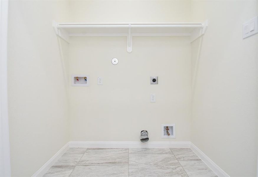 An empty closet with a single shoe, featuring a shelf, a hanging rod, and various utility outlets on the walls.