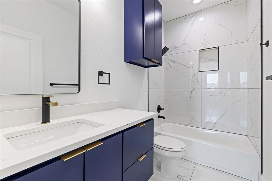 Bathroom with shower / washtub combination, vanity, and light marble finish floors
