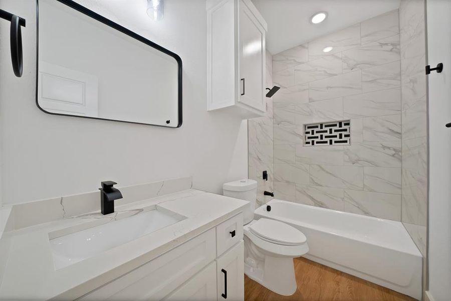 Bathroom with light wood-style floors, vanity, and shower / washtub combination