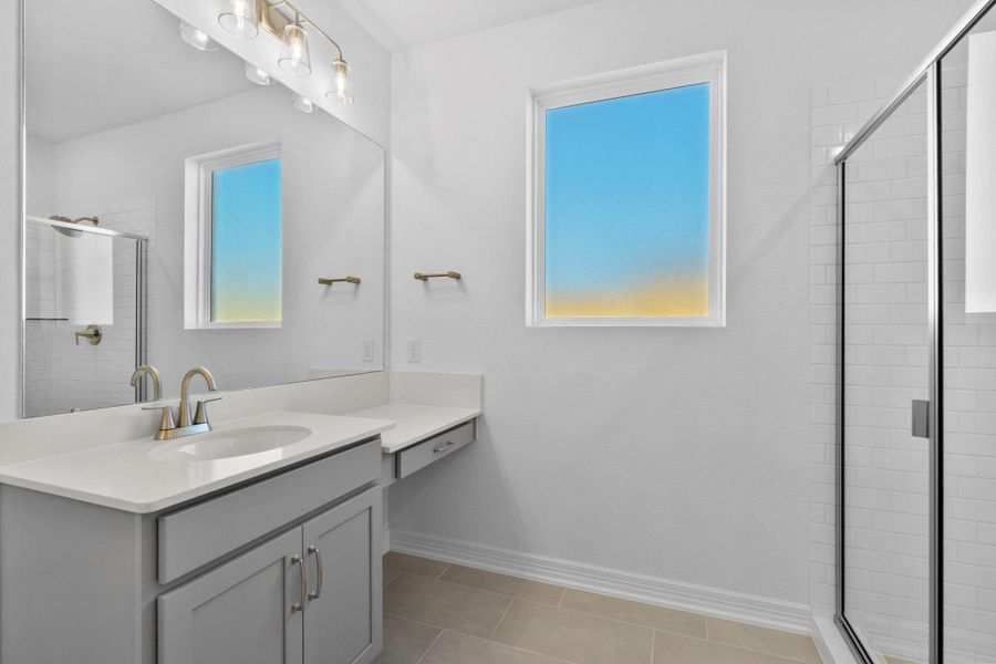 The en-suite bathroom offers a spa-like atmosphere with its elegant design, high end finishes, and tasteful lighting, creating a retreat within your own home.