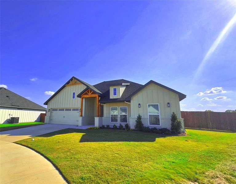 View of front facade featuring board and batten siding, concrete driveway, brick siding, a shingled roof, and an attached garage View of front facade featuring board and batten siding, concrete driveway, brick siding, a shingled roof, and an attached garage