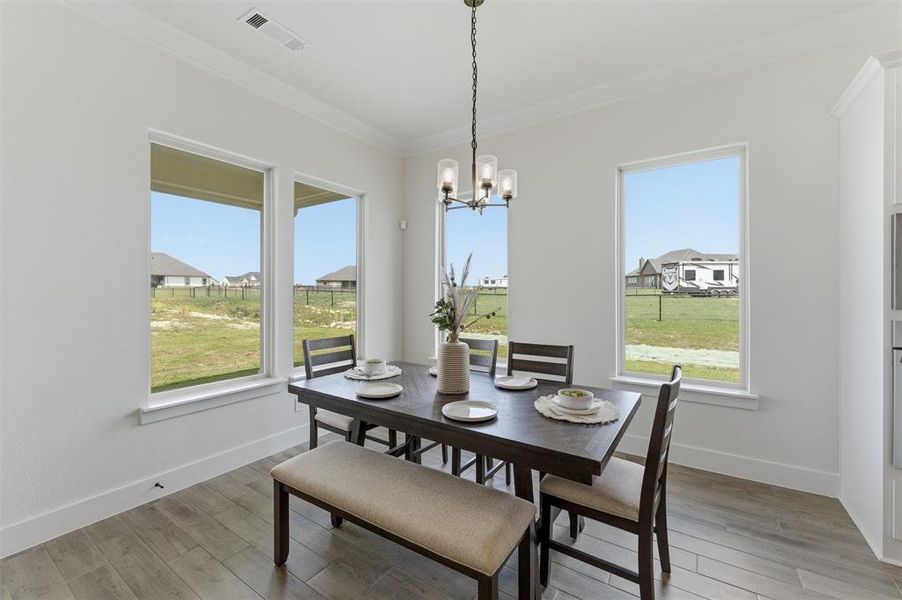Dining area featuring light wood-finish flooring and multiple large windows