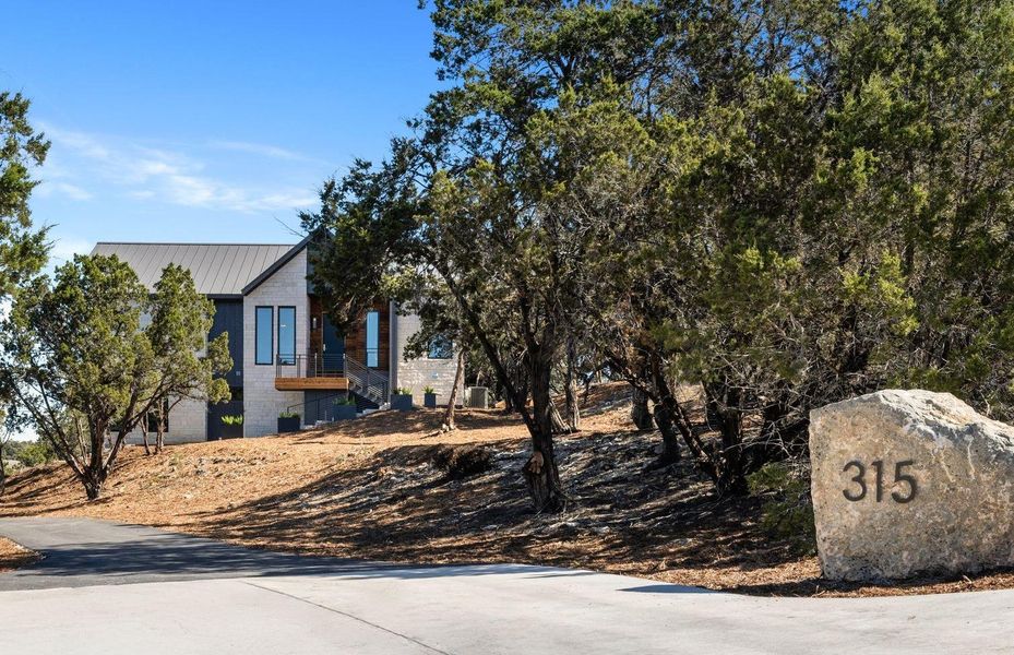 View of home's exterior featuring stairway, metal roof, and concrete block siding