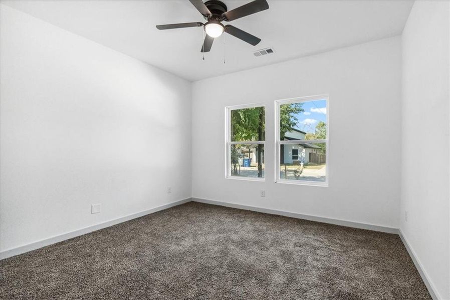 Empty room featuring ceiling fan and carpet