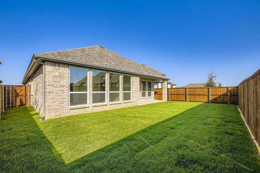 Back of property featuring a shingled roof, a patio area, a fenced backyard, and brick siding Back of property featuring a shingled roof, a patio area, a fenced backyard, and brick siding