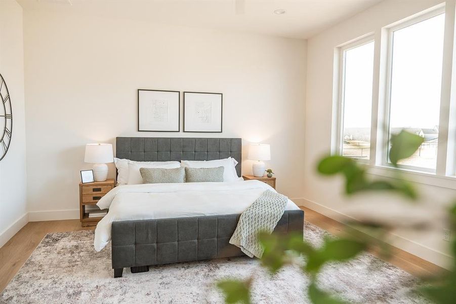 Bedroom featuring baseboards and wood finished floors Bedroom featuring baseboards and wood finished floors