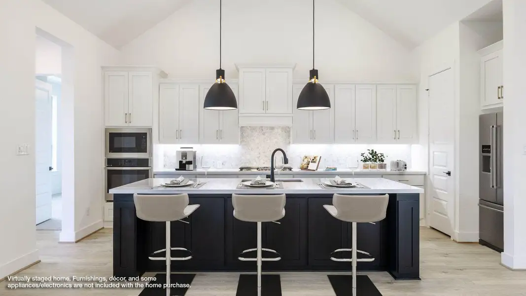 Kitchen with dark cabinets, a breakfast bar area, an island with sink, backsplash, and appliances with stainless steel finishes Kitchen with dark cabinets, a breakfast bar area, an island with sink, backsplash, and appliances with stainless steel finishes