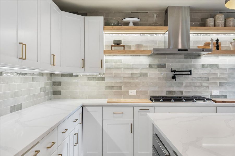 Kitchen featuring island range hood, light stone counters, white cabinetry, and open shelves