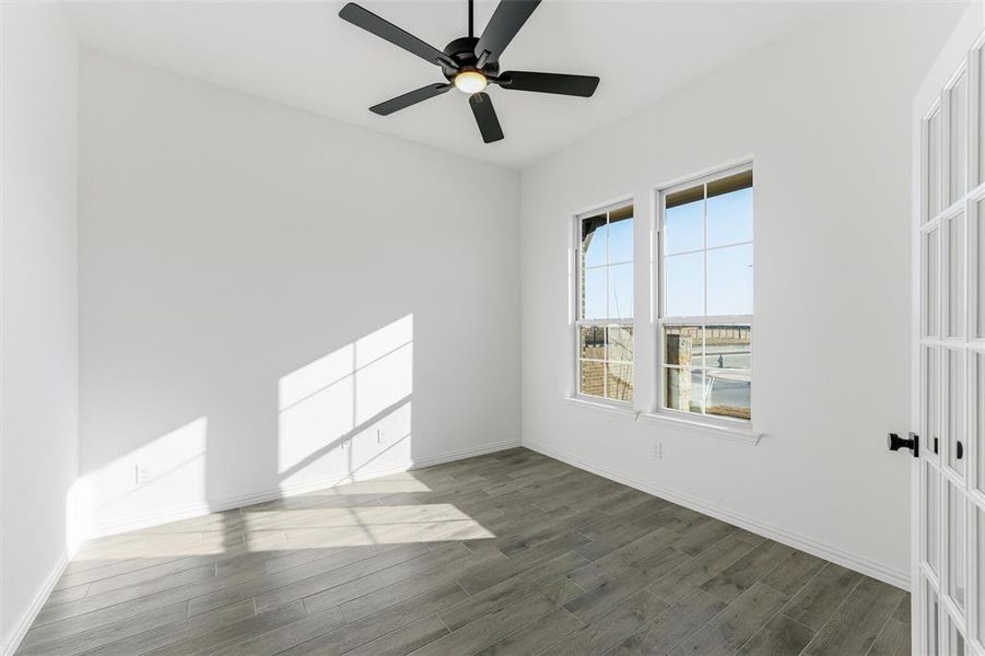 Spare room featuring dark wood finished floors and ceiling fan