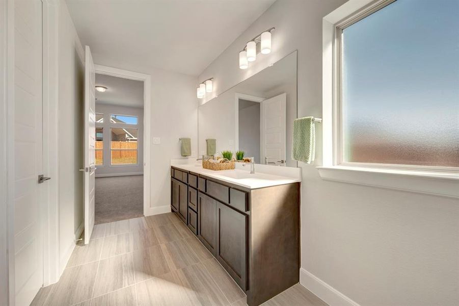 Full bath with double vanity and light tile patterned floors