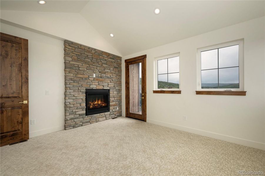 Master bedroom with fireplace and balcony.