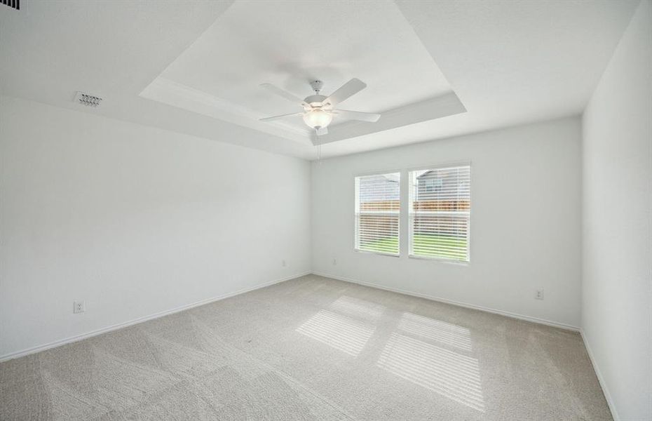 Elegant owner's suite with tray ceiling *real home pictured